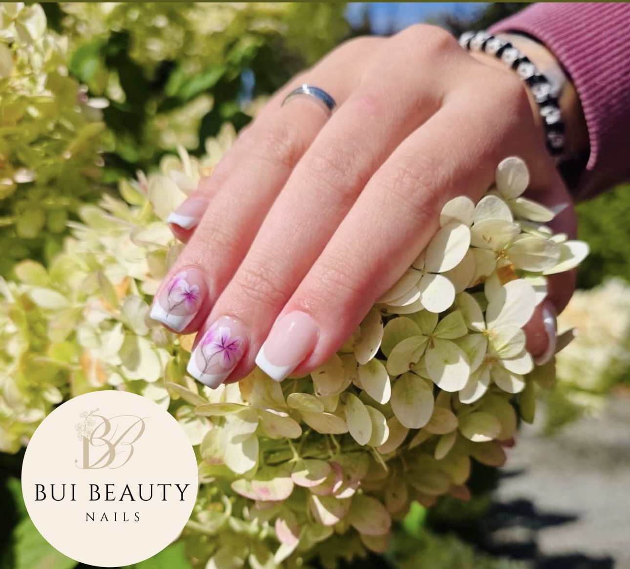 Witte nagels met lila bloemen tussen hortensia's