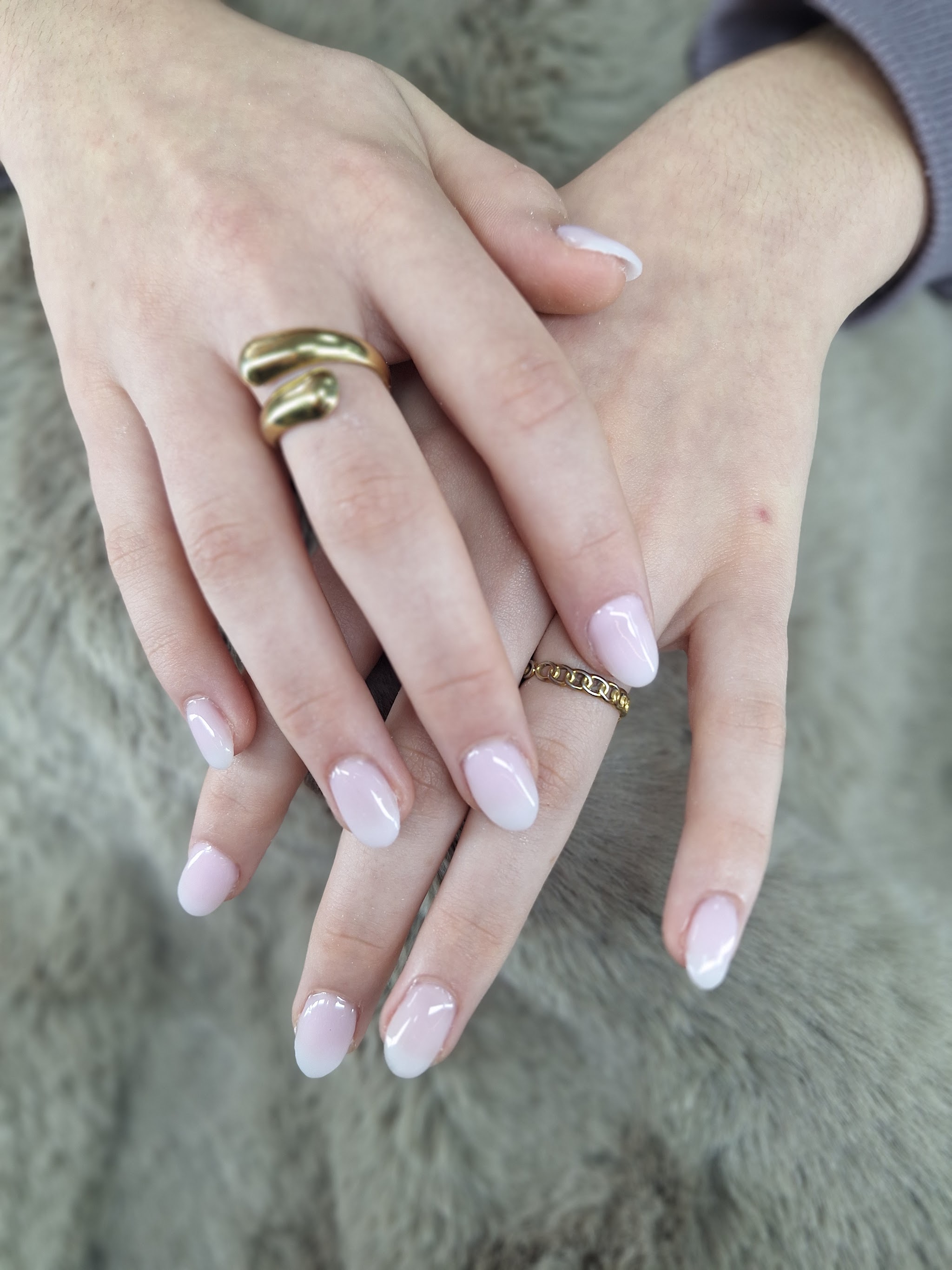Melkwitte amandelvormige nagels met gouden ringen